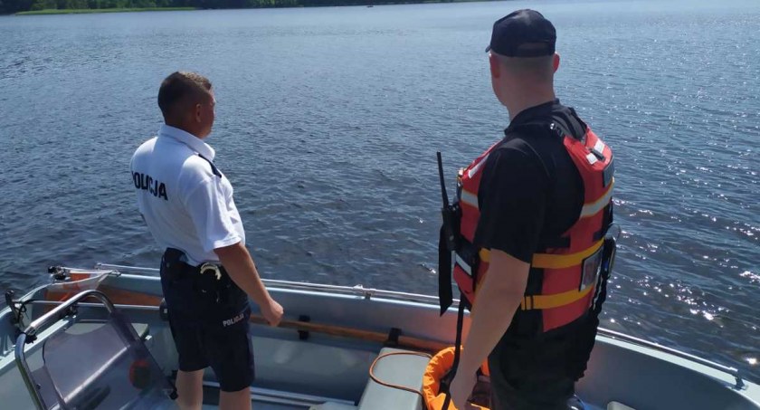 Zdjęcie policjanta i strażaka na łódce na jeziorze Pomorze
