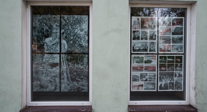 Zdjęcie dwóch okien w pierzei kamienic ulicy Piłsudskiego z wystawą fotografii