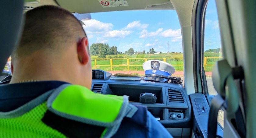 Zdjęcie policjanta siedzącego na miejscu kierowcy w radiowozie
