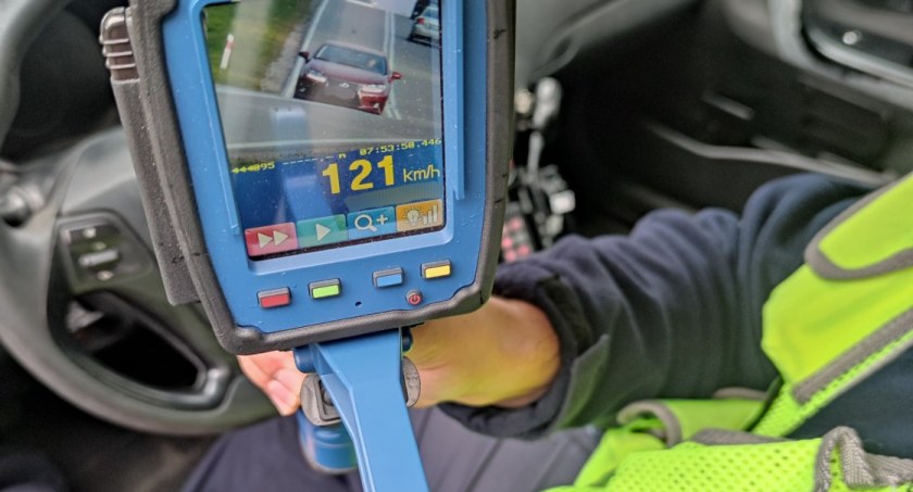 Zdjęcie policjanta pokazującego odczyt z radaru