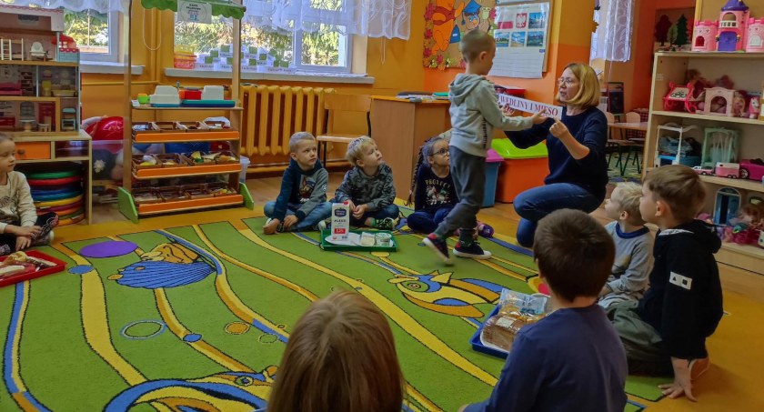 Zdjęcie dzieci i nauczycielki w trakcie zajęć edukacyjnych w sali przedszkolnej