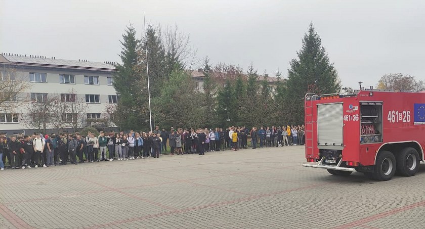 Zdjęcie uczniów zgromadzonych po ewakuacji na szkolnym placu
