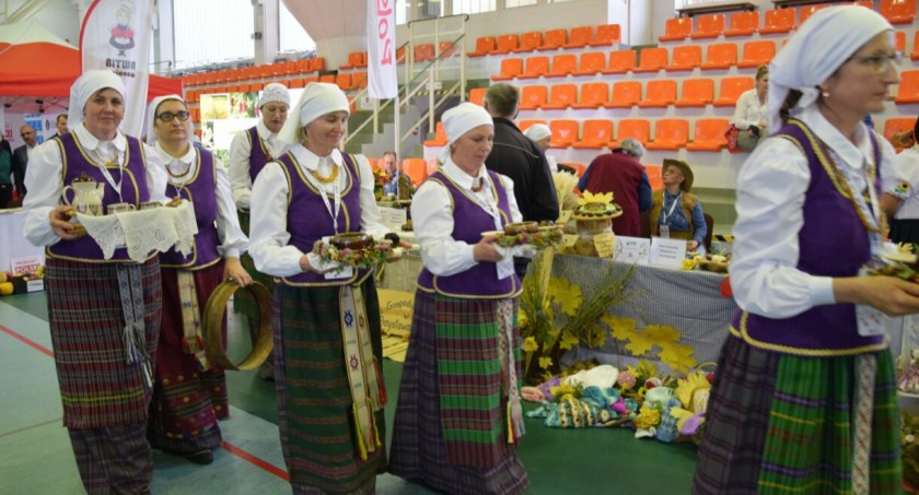 Zdjęcie gospodyń z gminy Puńsk niosących potrawy do oceny jurorom