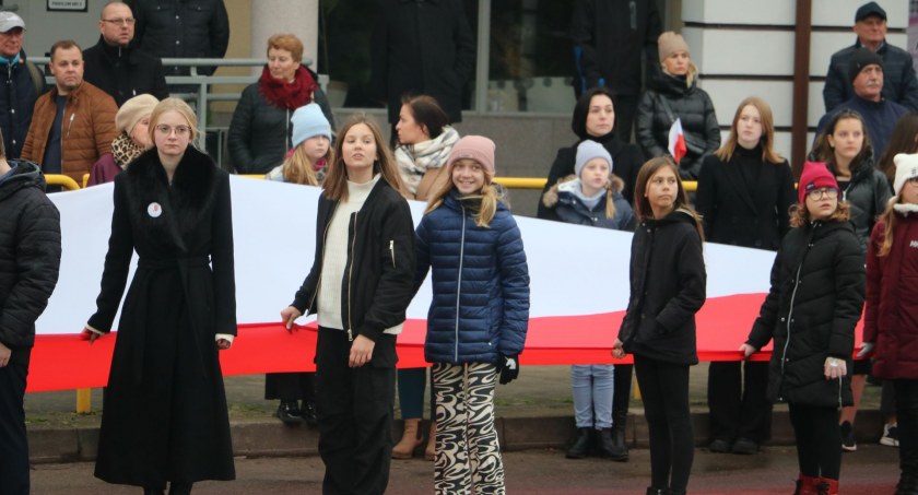 Zdjęcie mieszkańców Sejn niosących stumetrową flagę 