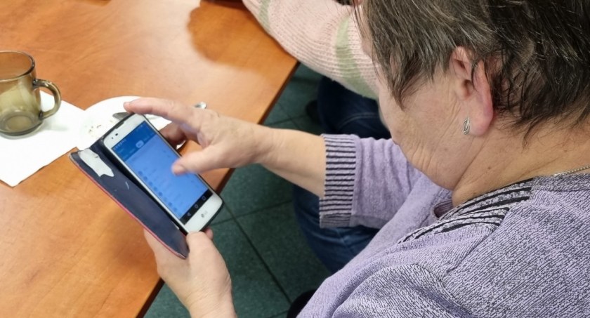 Zdjęcie kobiety przeglądającej aplikację na smartfonie