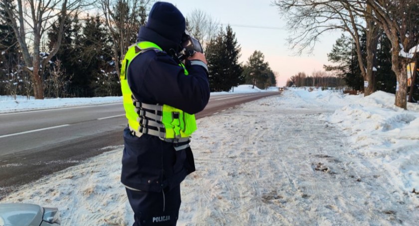 Zdjęcie policjanta z miernikiem prędkości na tle zimowego otoczenia