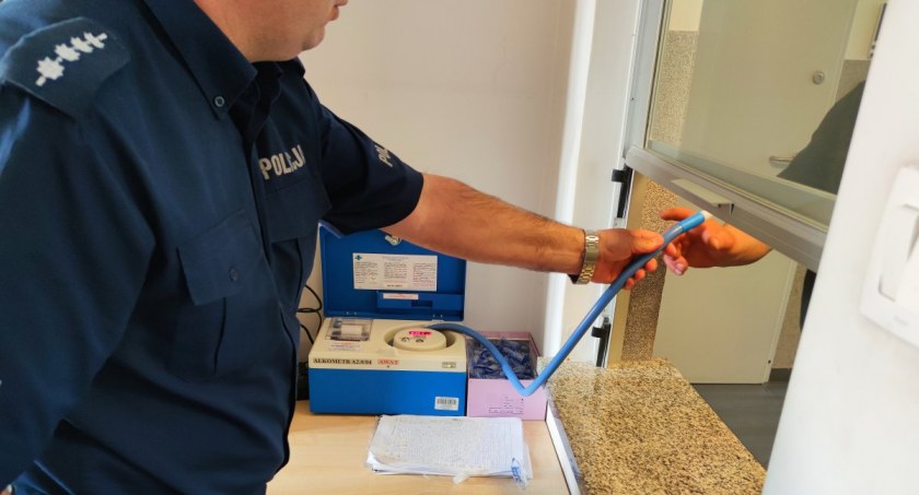 Zdjęcie dyżurnego Policji podającego ustnik alkometru