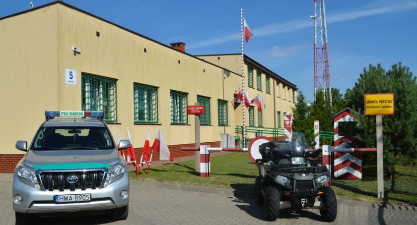 Zdjęcie strażnicy SG przy ul. Łąkowej w Sejnach z zaparkowanym autem i quadem
