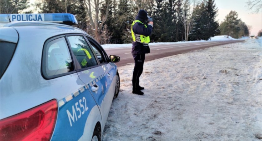 Zdjęcie policjanta z miernikiem prędkości na tle zimowego otoczenia