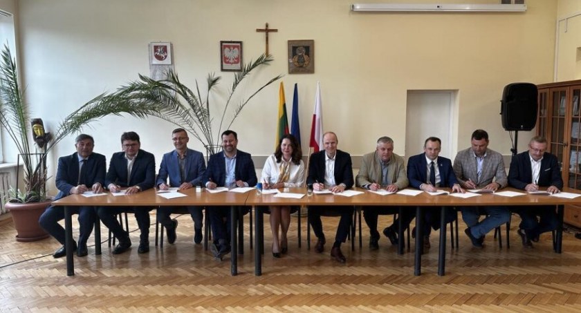 Sygnatariusze umowy o współpracy siedzący za stołem w UG Puńsk, fot. lazdijai.lt