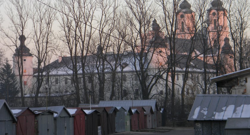 Zdjęcie garaży na tle klasztoru podominikańskiego w Sejnach